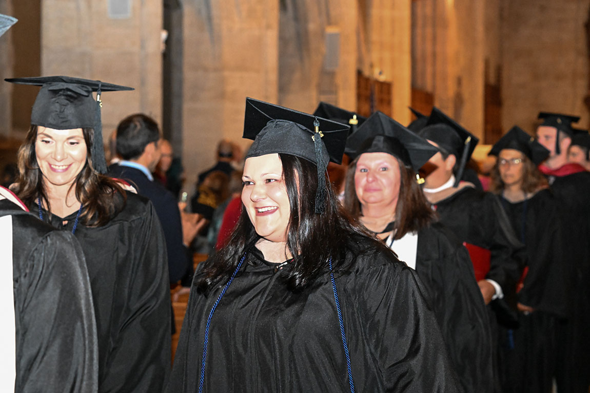 Smiling graduates process out of Egner Chapel during Commencement